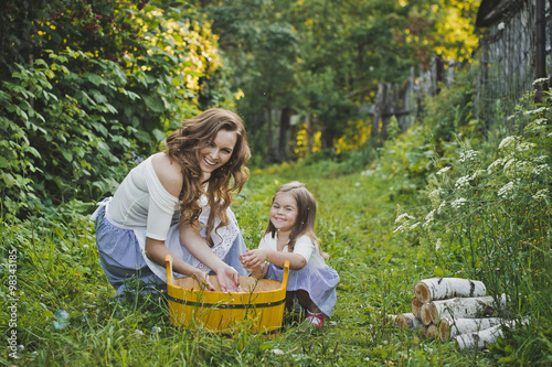 Daughter with mother washing clothes in nature 4706. © alenazamotaeva