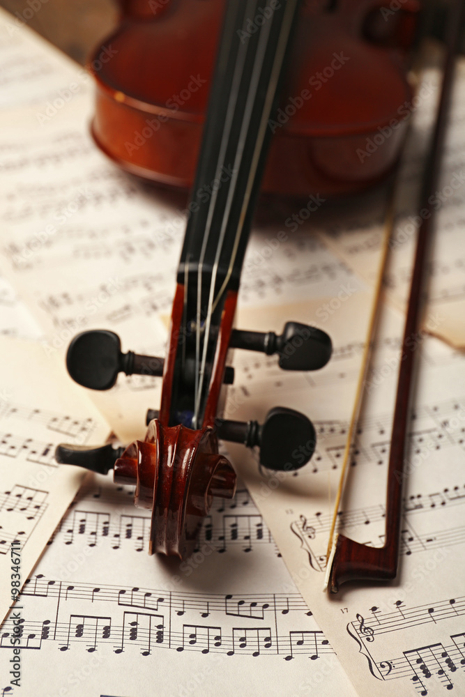 Naklejka premium Violin neck on music papers background