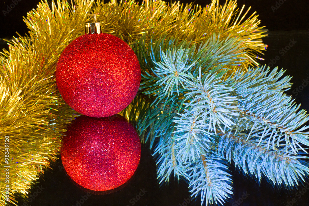 красный шар,ветка голубой елки и золотая мишура Photos | Adobe Stock