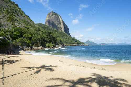 Praia Vermelha Red Beach quiet afternoon with view of Sugarloaf Mountain Pao de Acucar and palm tree shadows Rio de Janeiro Brazil