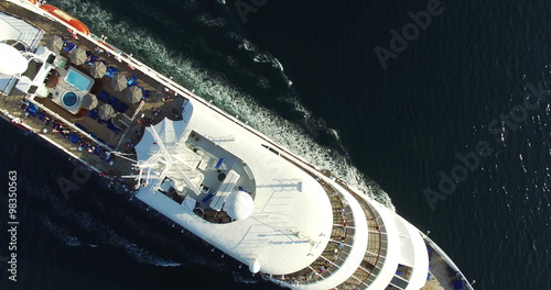 Aerial view of luxury medium cruise ship sailing from port on sunrise