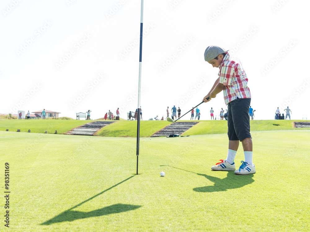 Obraz premium Kid playing golf at club