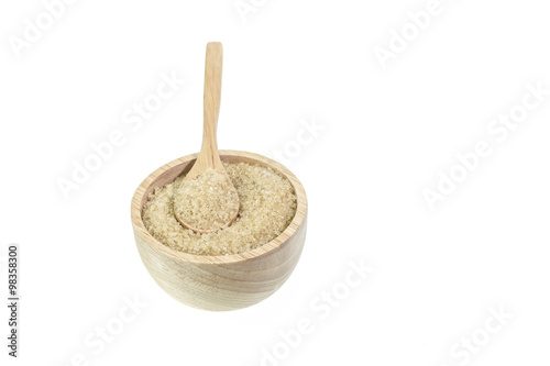 Close up of brown sugar in wooden bowl isolated on white