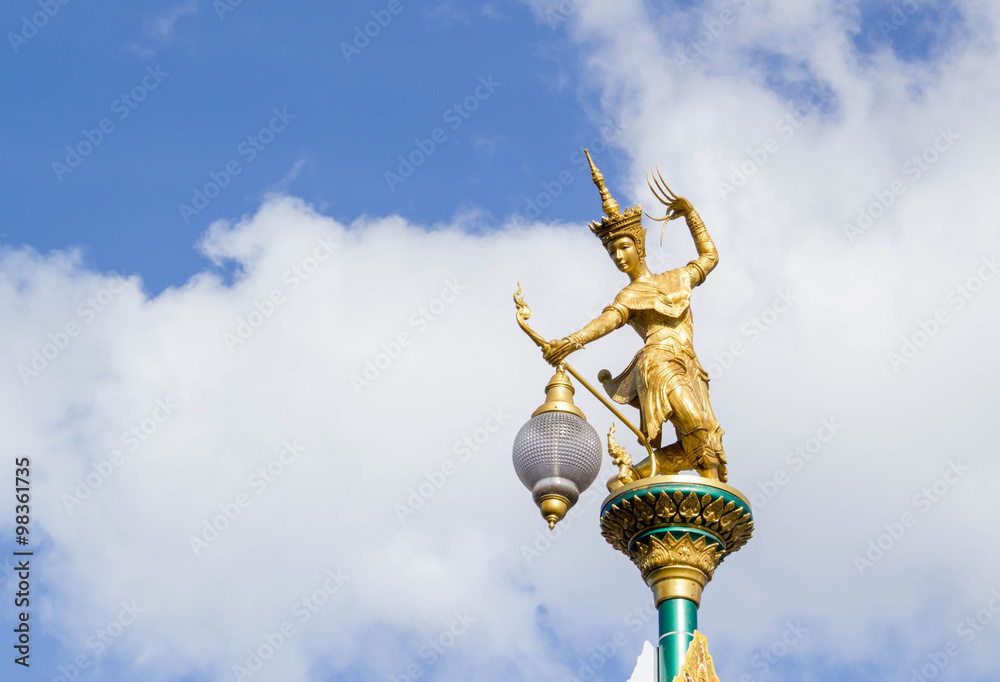 Golden statue of native thai art with street lamps