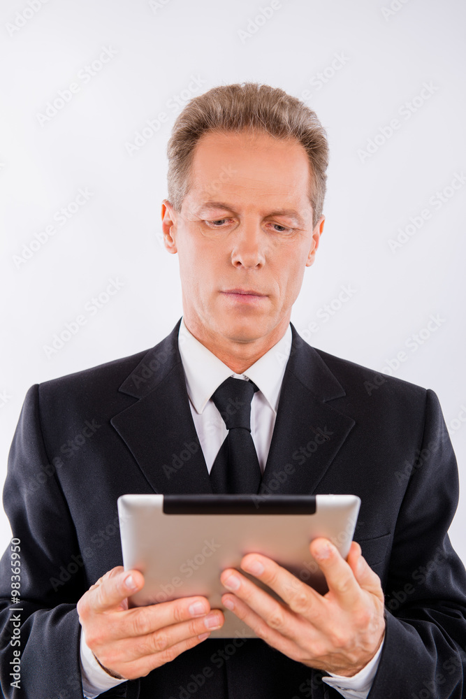 A mature serious manager reading news in his laptop A mature serious manager reading news in his laptop