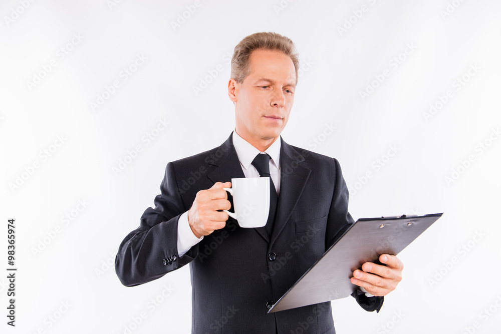 An attractive mature businessman with folder and mug in his hand An attractive mature businessman with folder and mug in his hand
