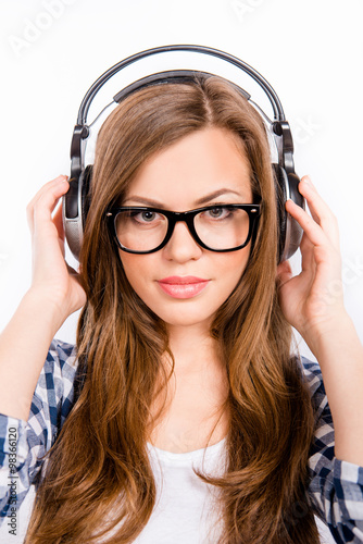 cute girl with glasses enjoying music on headphones