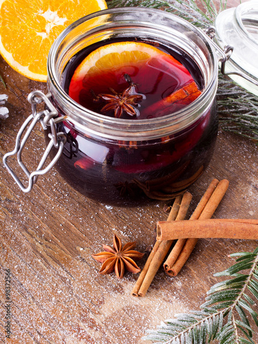 Christmas drink with orange fruit, anise, cinnamon and cloves on wooden table