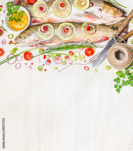 Fresh char with ingredients for fish dishes cooking on white wooden background, top view,border.  Healthy food or diet nutrition concept.