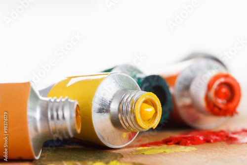 Oil paint tubes and pain brush over colorful artist's palette