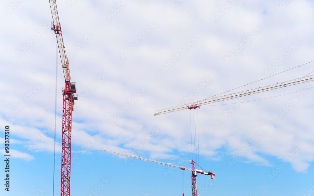 Tower cranes on cloudy sky background
Tower cranes on cloudy sky background