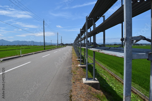 防雪柵／雪国の山形県で、防雪柵が設置された風景を撮影した写真です。夏場は防雪柵を畳んであり、見通しを妨げないようになってます。吹雪対策の為、本格的な降雪時期になると機能するように設置されます。冬場の猛吹雪の時は防雪柵がなければ、道路が瞬時に吹き溜まりで通行不能になるので非常に重要なものです。