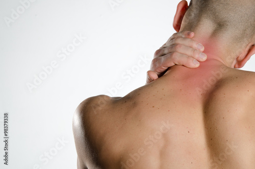 a young man holding neck in pain