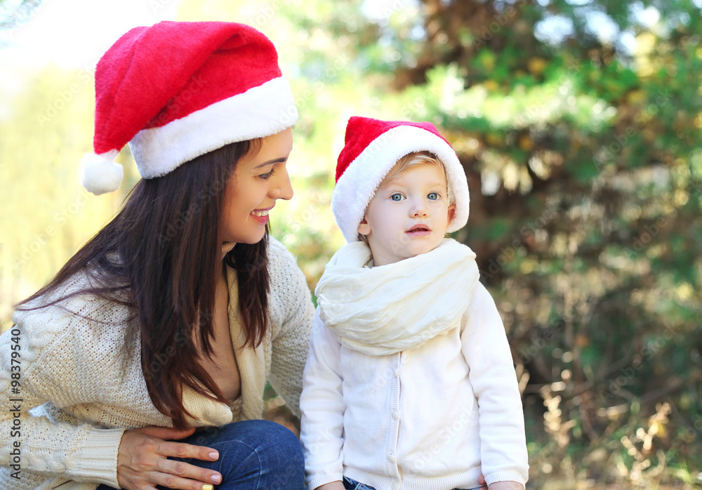 Christmas and family concept - happy mother and child in santa r Christmas and family concept - happy mother and child in santa r