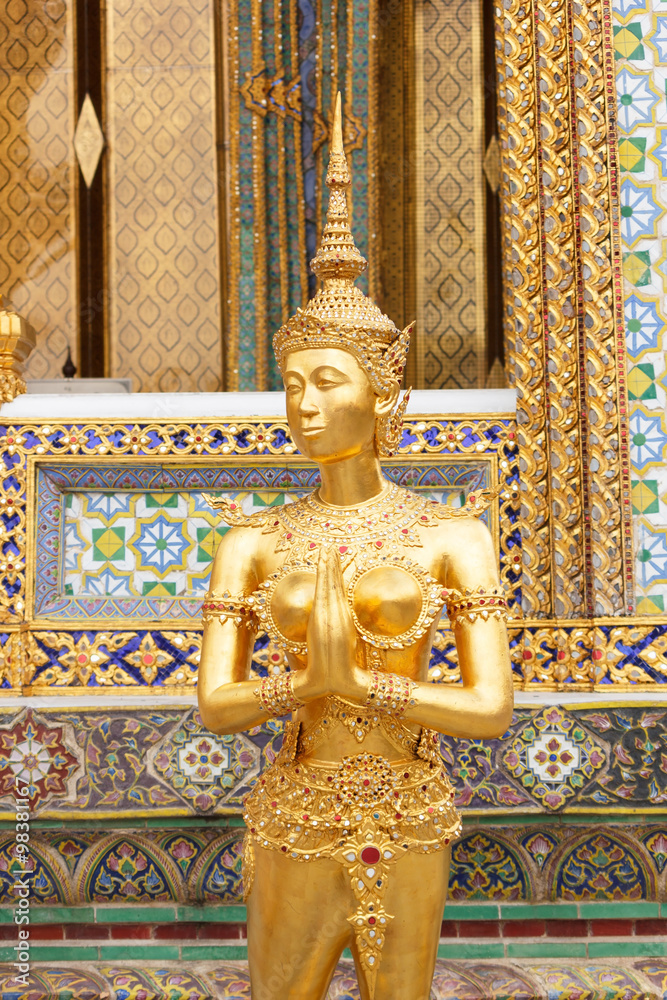 Gold Kinnaree statue, Thai angel woman at Wat Phra Kaew temple in Bangkok Thailand.