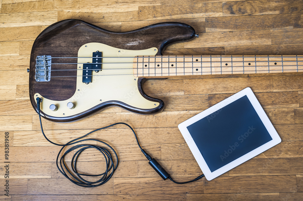 Naklejka premium Bass guitar on digital tablet