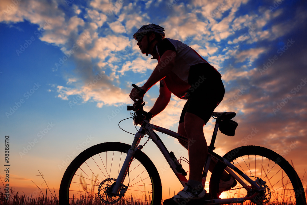 Obraz premium mountain biker silhouette in sunrise