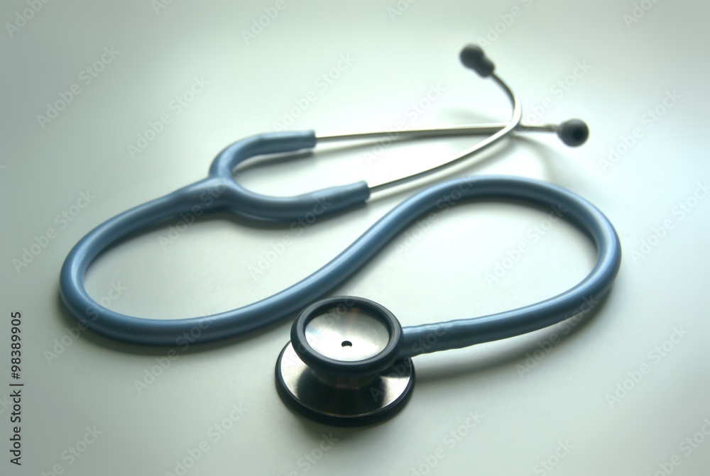 Single light blue stethoscope on a desk at a clinic next to a window