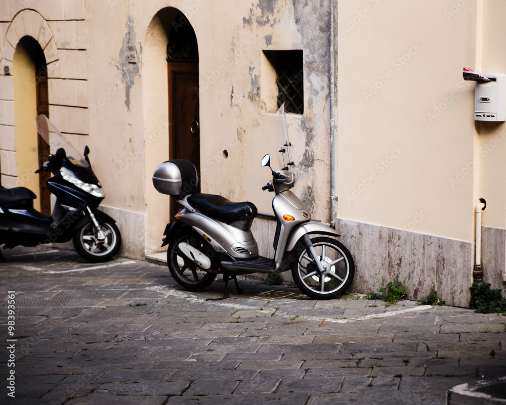 motor scooter parked in front of a building wall