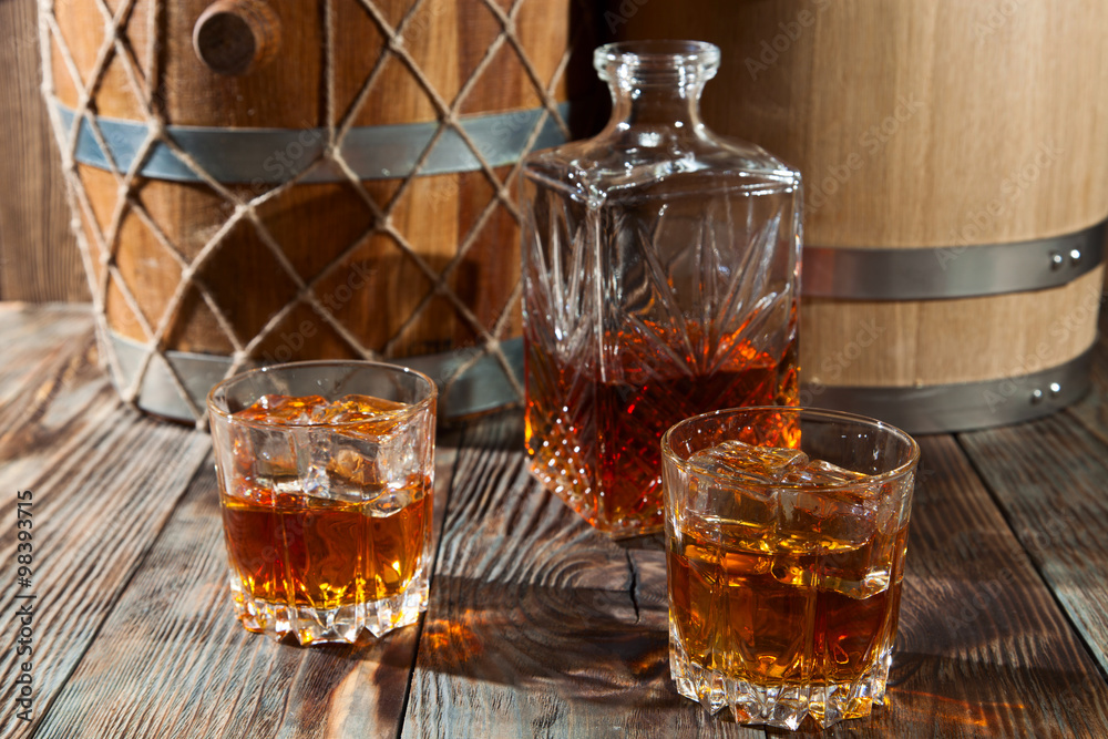 Two glasses of whiskey with ice and decanter Two glasses of whiskey with ice and decanter