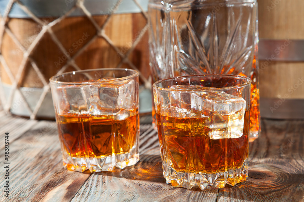 Two glasses of whiskey with ice and decanter Two glasses of whiskey with ice and decanter