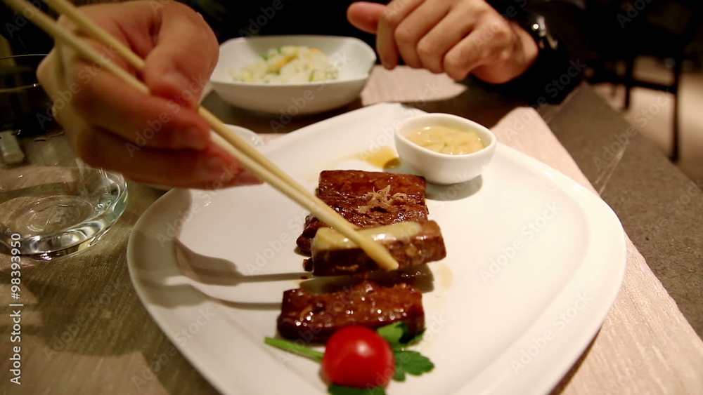 man shows a typical piece of grilled, seared tuna recipe Japanese, before eating- at japanese restaurant- slow motion man shows a typical piece of grilled, seared tuna recipe Japanese, before eating- at japanese restaurant- slow motion