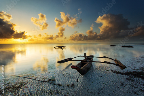 Traditional fisher boat in Zanzibar on a white beach at a beauti photo