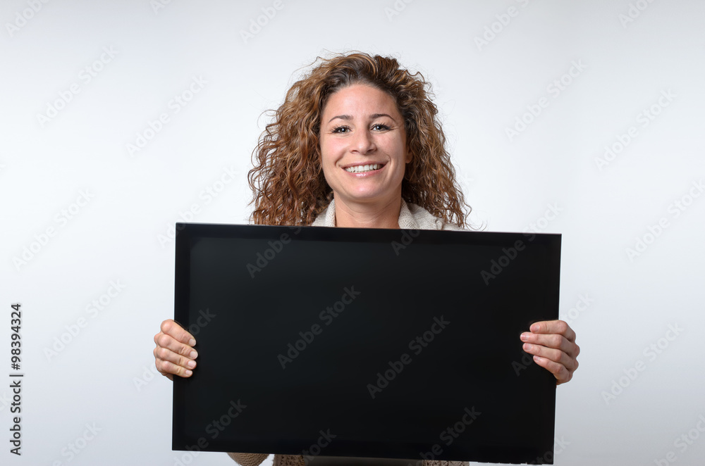 Naklejka premium Young woman holding up a blank monitor