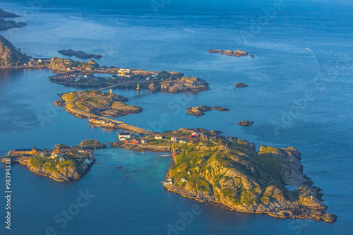 Fototapeta Naklejka Na Ścianę i Meble -  Aerial view of small seaside town situated at the foot of a mountain,bridge, green islands and sea at sunset  in Norway