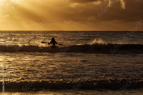 Fototapeta Naklejka Na Ścianę i Meble -  Man in kayak on ocean with big waves at beautiful sunrise