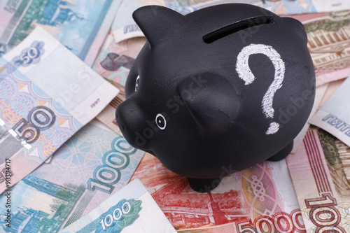 Black piggy bank with question mark and russian rubles