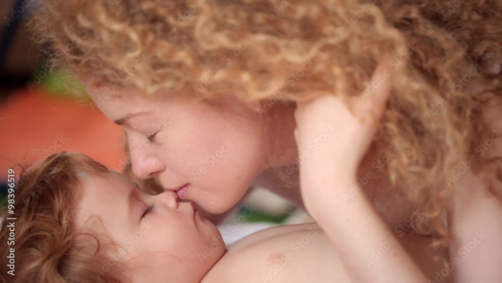 happy family, a gentle kiss from his mother for the child who sleeps during the day happy family, a gentle kiss from his mother for the child who sleeps during the day