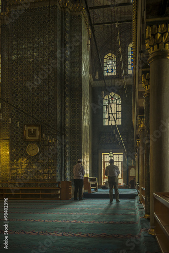 Muslim guy praying inside ancient Ottoman mosque in Istanbul photo