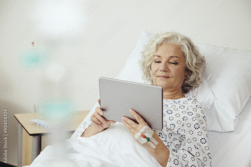 Senior woman in hospital using digital tablet Senior woman in hospital using digital tablet