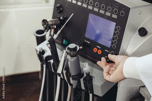 ENT doctor turning a knob at medical device in practice photo