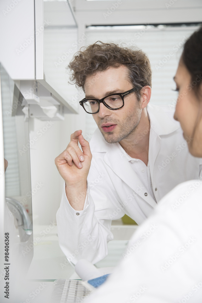 Two doctors at computer screen discussing Two doctors at computer screen discussing