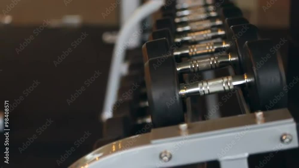 Sports dumbbells rubber in modern sports club. Weight Training Equipment. Camera in motion Sports dumbbells rubber in modern sports club. Weight Training Equipment. Camera in motion