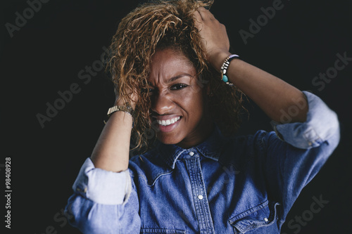 Portrait of woman tearing her hair in front of black background