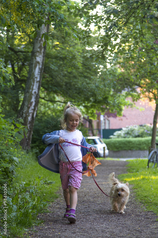 Little girl walking with her dog