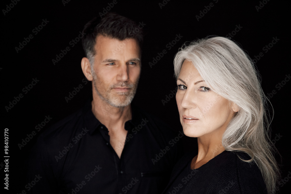 Portrait of mature man and mature woman wearing black clothes in front of black background Portrait of mature man and mature woman wearing black clothes in front of black background