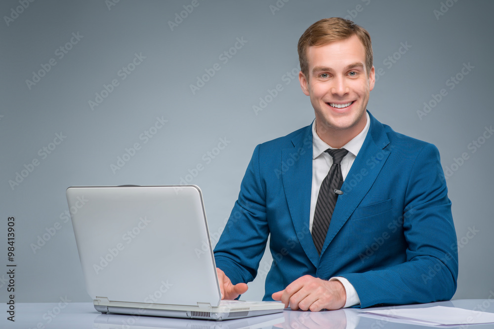 Smiling newsman working with his laptop. Smiling newsman working with his laptop.