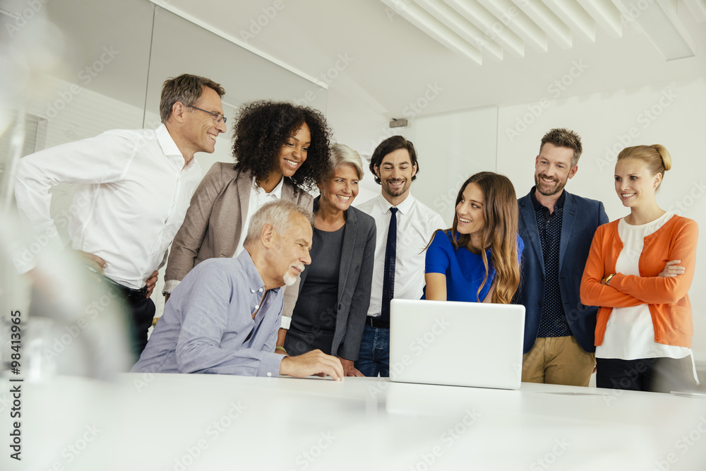 Business people attending laptop presentation in conference room