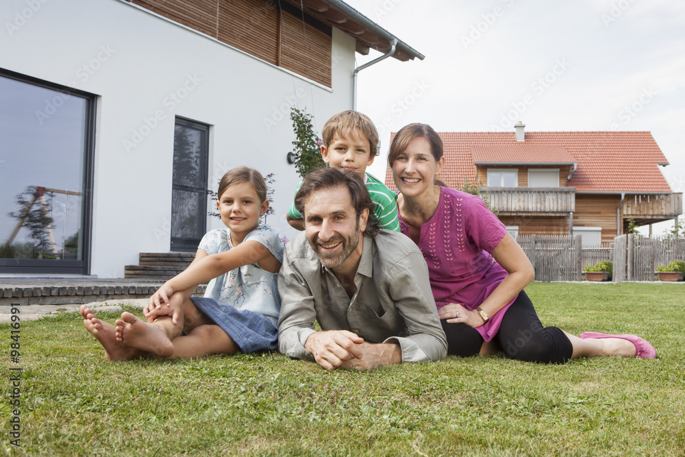 Portrait of smiling family of four in garden Portrait of smiling family of four in garden