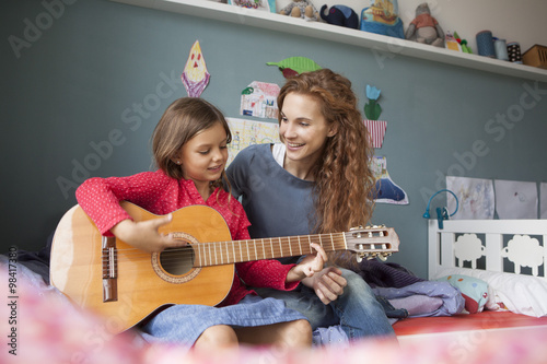Wallpaper Mural Little girl playing guitar while her mother listening Torontodigital.ca