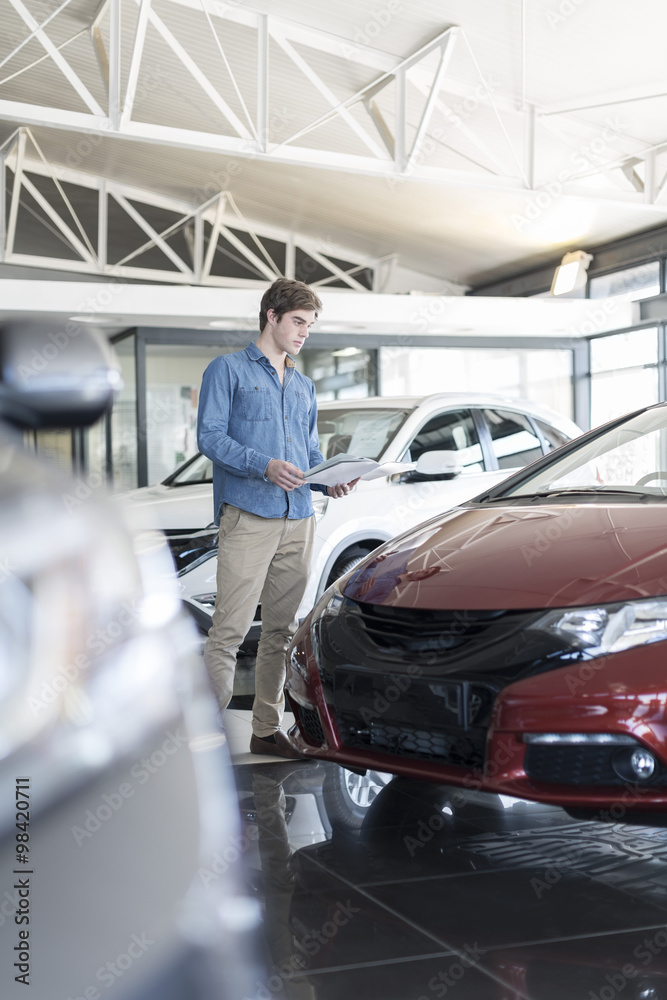 Man looking at new car at car dealership Man looking at new car at car dealership