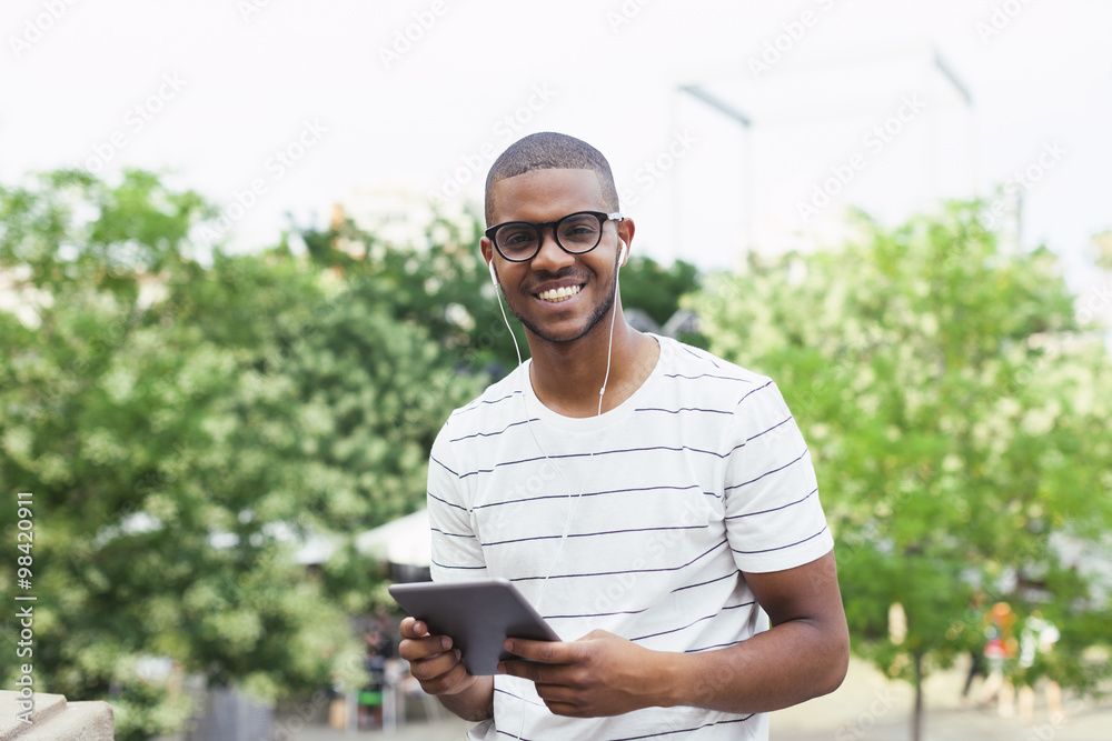 Young Afro American student with digital tablet and ear phones Young Afro American student with digital tablet and ear phones
