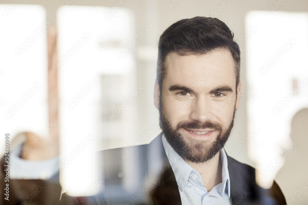 Portrait of smiling businessman behind glass wall Portrait of smiling businessman behind glass wall
