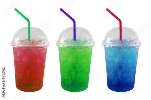 Green, Red and Blue soda and ice in plastic grass isolated on wh