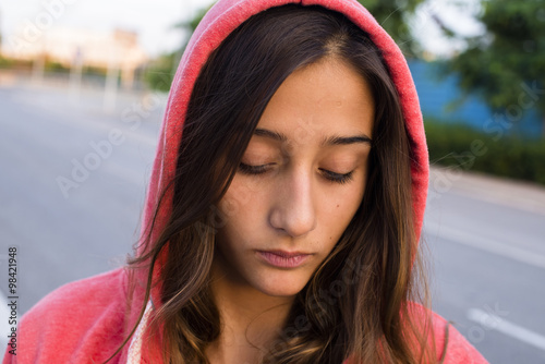 Sad girl wearing pink hoodie photo