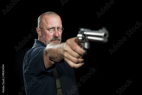 Mature man with revolver aiming